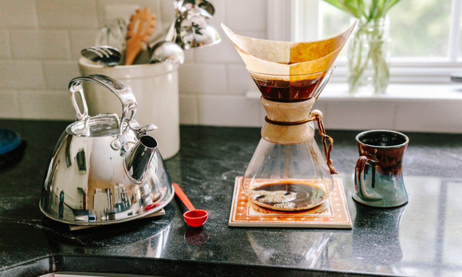 A close-up of a steaming cup of coffee with cinnamon sprinkled on top, next to coffee beans and a cinnamon stick, suggesting a healthy and flavorful start to the day.