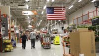 Assortment of cordless power tools including drills, saws, and grinders from brands like DeWalt, Milwaukee, and Ryobi on sale at Home Depot.