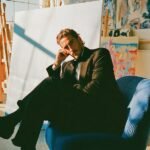 The Unyielding Canvas: Why Human Creativity Defies the AI Revolution 8 An artist's hand painting a canvas, with digital elements and AI-inspired patterns subtly integrated, symbolizing the fusion of human creativity and artificial intelligence.