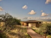 Kitirua Plains Lodge exterior showing curved earth-formed walls blending into the Kenyan landscape with Mount Kilimanjaro in the background.