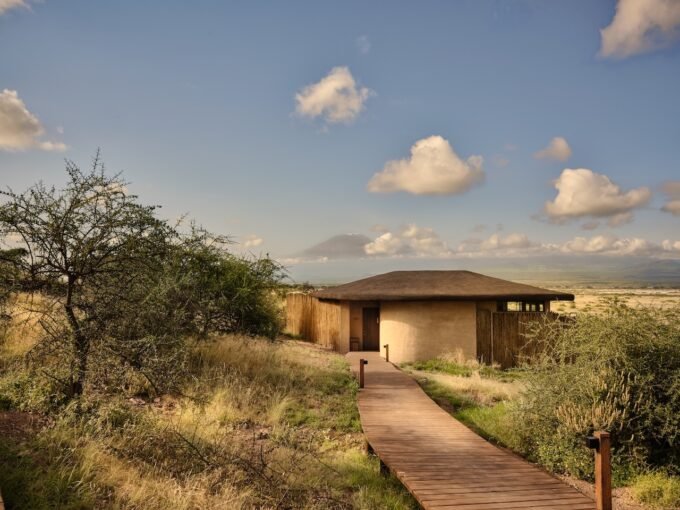 Kitirua Plains Lodge exterior showing curved earth-formed walls blending into the Kenyan landscape with Mount Kilimanjaro in the background.