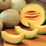 Melons frais du Maroc sur un étal de marché, symbolisant le succès de la production marocaine.