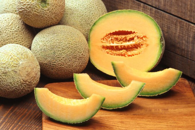 Melons frais du Maroc sur un étal de marché, symbolisant le succès de la production marocaine.