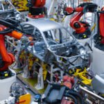 Le Maroc sur la Voie Rapide : Leader Africain de l'Export Automobile et de la Production de Voitures Particulières 3 Vue aérienne d'une usine automobile moderne au Maroc, avec des voitures neuves alignées et des camions de transport, symbolisant le succès de l'exportation.