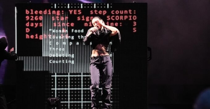Lorde performing on stage at the 2026 Governors Ball, holding a microphone.