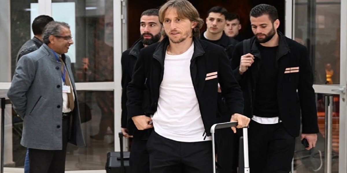 Luka Modric souriant, portant le maillot de l'AC Milan, célébrant un but ou une victoire.