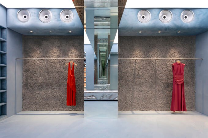 Interior view of Lady Pipa's Madrid flagship store with blue resin floor, limewashed walls, and mirrored arches, evoking a David Lynch film set.
