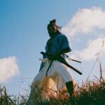 A person meditating with a samurai sword in the background, symbolizing modern discipline and ancient wisdom.