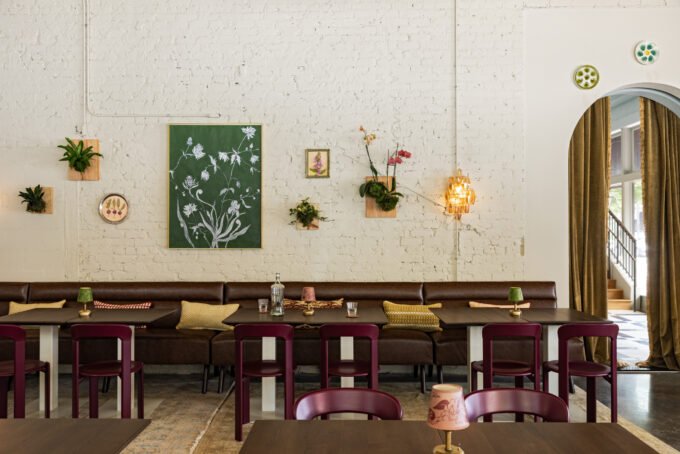 Interior view of Charles & Julia cocktail lounge, featuring oxblood velvet drapery, vintage European furnishings, and a Calacatta Viola marble bar.