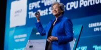 AMD CEO Lisa Su speaking at the Advancing AI conference, with a graphic related to AI technology in the background.