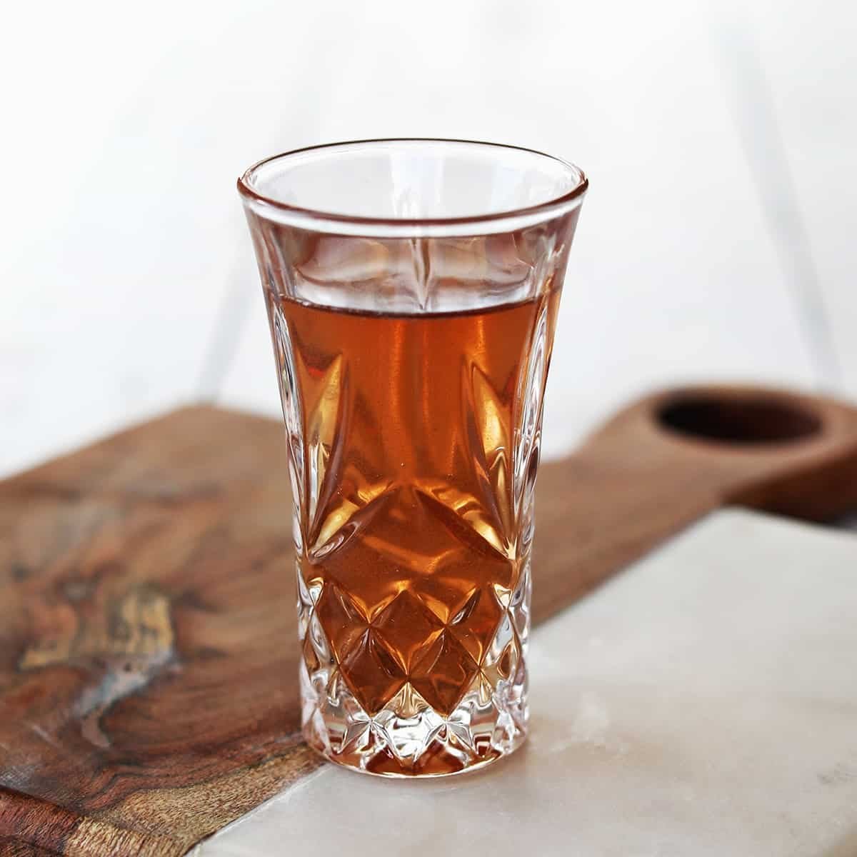 A perfectly crafted Peanut Butter and Jelly Shot in a shot glass, garnished with a tiny PB&J sandwich.