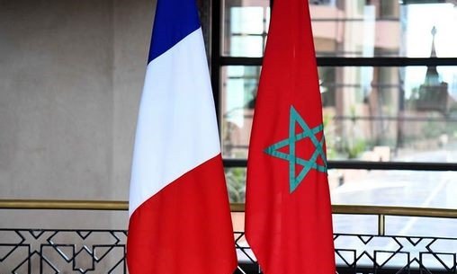 Les drapeaux du Maroc et de la France flottant côte à côte, symbolisant l'amitié et la coopération bilatérale lors de la réunion de haut niveau à Rabat.