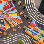 Overhead view of Sharmistha Ray's 'Geometry of Play' pickleball courts at Arts Landing in Pittsburgh, featuring colorful geometric patterns with players on the court.