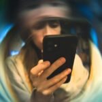 A hand holding a smartphone displaying an article in a clean, optimized reading mode, with a blurred background.