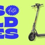 Une trottinette électrique Navee V40i Pro II de couleur noire, élégante et robuste, garée sur un trottoir urbain, avec son guidon replié pour illustrer sa compacité.