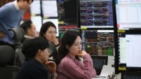 Currency dealers monitor exchange rates in a foreign exchange dealing room at Hana Bank headquarters in Seoul, amidst South Korea's volatile Kospi market.