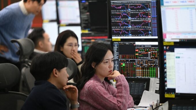 Currency dealers monitor exchange rates in a foreign exchange dealing room at Hana Bank headquarters in Seoul, amidst South Korea's volatile Kospi market.