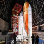 Space Shuttle Endeavour displayed vertically in launch position with solid rocket boosters and external tank at the California Science Center.