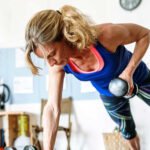 An older adult confidently lifting weights in a gym, demonstrating strength and vitality.
