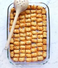 Golden brown Tater Tot Casserole bubbling hot, topped with fresh chives