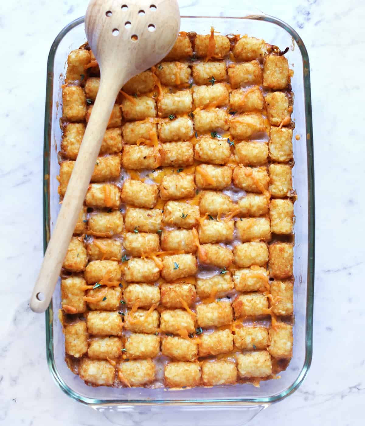 Golden brown Tater Tot Casserole bubbling hot, topped with fresh chives