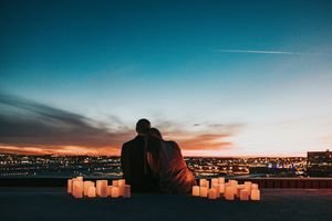 A couple watching the sunrise over Haleakalā volcano in Maui, Hawaii, during their honeymoon.