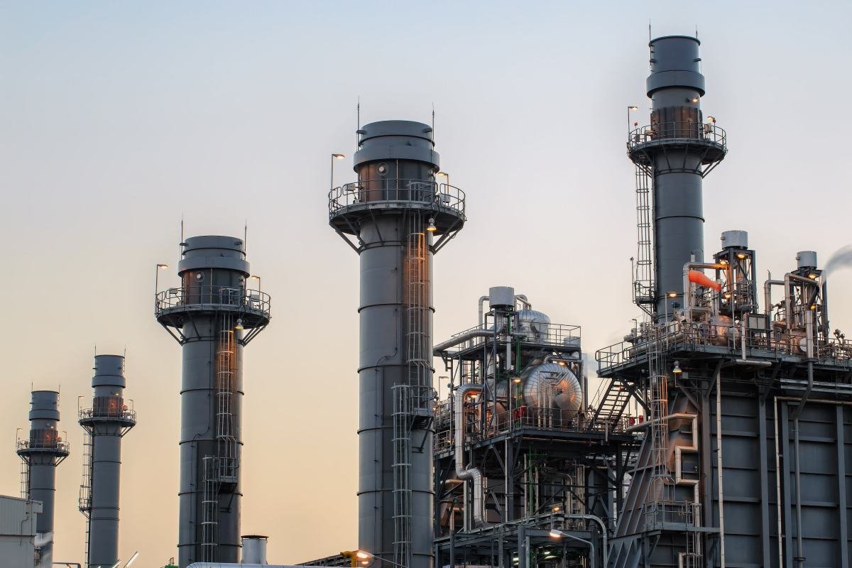 Illustration of a large data center with smoke stacks emitting carbon dioxide, symbolizing climate pollution.