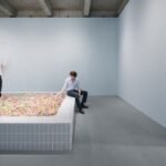 Visitors interacting with Cj Hendry's 'Pastel' installation, a vast pit filled with millions of colorful pastel beads, at Salon 94 Design.