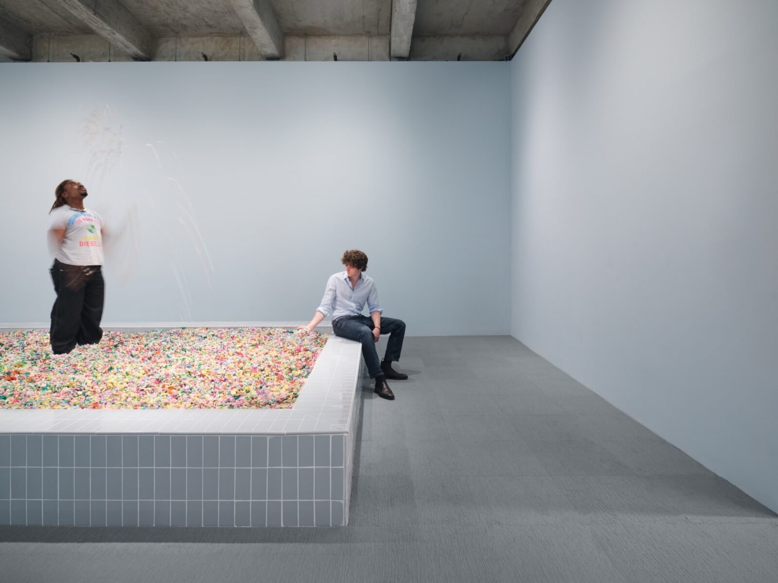 Visitors interacting with Cj Hendry's 'Pastel' installation, a vast pit filled with millions of colorful pastel beads, at Salon 94 Design.