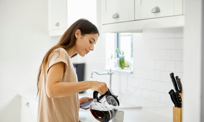 A steaming cup of coffee next to a heart monitor, symbolizing the link between coffee consumption and cardiovascular health.