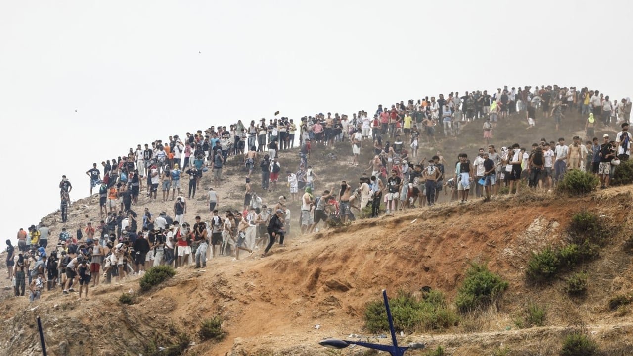 Des migrants se rassemblent sur une colline à la frontière hispano-marocaine près de Fnideq, tentant de rejoindre Ceuta, le 31 juillet 2026.