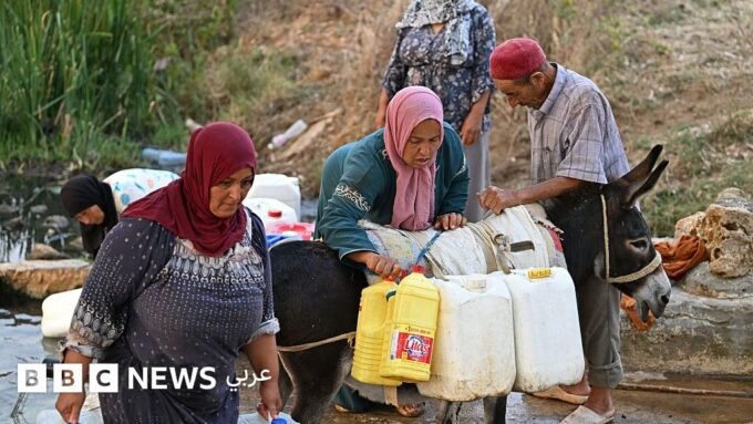 صورة لزجاجات مياه معدنية فارغة أو رفوف سوبر ماركت خالية، تعكس أزمة نقص المياه في تونس.