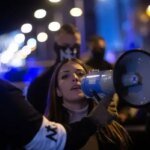 ناشطة نيونازية تتحدث عبر مكبر صوت خلال مظاهرة في مدريد