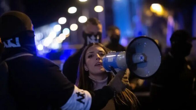 ناشطة نيونازية تتحدث عبر مكبر صوت خلال مظاهرة في مدريد