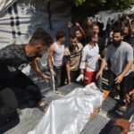 فلسطينيون يحملون جثمان ضحية بعد غارة إسرائيلية استهدفت مقر الشرطة البلدية في مدينة غزة.