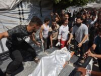 فلسطينيون يحملون جثمان ضحية بعد غارة إسرائيلية استهدفت مقر الشرطة البلدية في مدينة غزة.