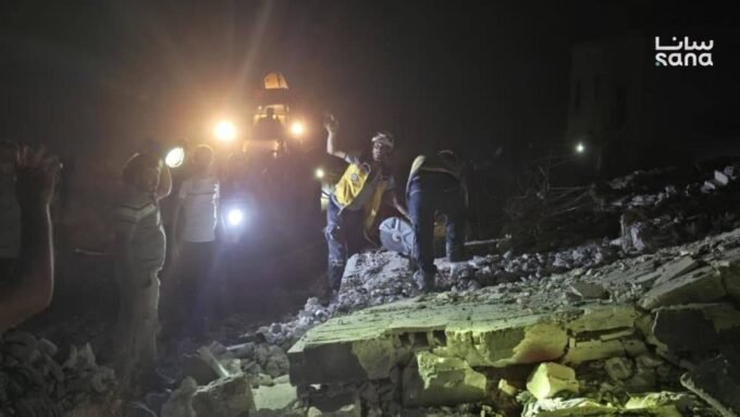صورة تظهر آثار الدمار وعناصر الدفاع المدني في موقع انفجار بقرية عين القصب بريف إدلب الغربي، سوريا.