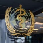 شعار منظمة الصحة العالمية مع إشارة إلى تفشي فيروس إيبولا في جمهورية الكونغو الديمقراطية.