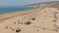 منظر بانورامي لشاطئ أكادير يعج بالمصطافين مع البحر الأزرق ورمال ذهبية