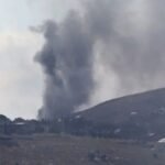 صورة جوية تظهر آثار غارة إسرائيلية على منطقة ريفية في جنوب لبنان، مع تصاعد للدخان.