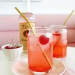 The Dirty Shirley: A Grown-Up Twist on a Childhood Classic 6 A vibrant red Dirty Shirley cocktail garnished with maraschino cherries and a lime slice in a tall glass.