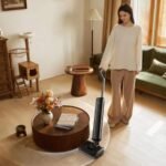 Ce nouvel aspirateur laveur ultra-plat signé Dreame profite déjà d’une promo chez Boulanger 8 Aspirateur balai laveur Dreame T12 Pro en action, avec son manche incliné sous un meuble bas, illustrant sa finesse et sa maniabilité.