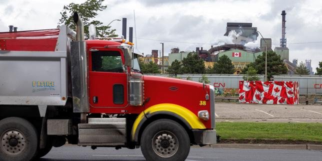 Drapeaux du Canada et des États-Unis, symbolisant les tensions commerciales.