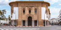 Une pile de dirhams marocains, symbolisant l'augmentation du cash en circulation, avec en arrière-plan des éléments suggérant la digitalisation des paiements, comme une carte bancaire ou un smartphone.