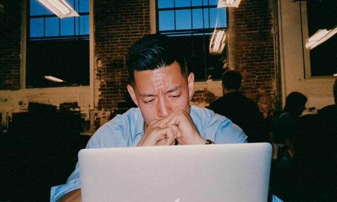 An entrepreneur staring at a blinking cursor on a laptop, symbolizing execution paralysis.