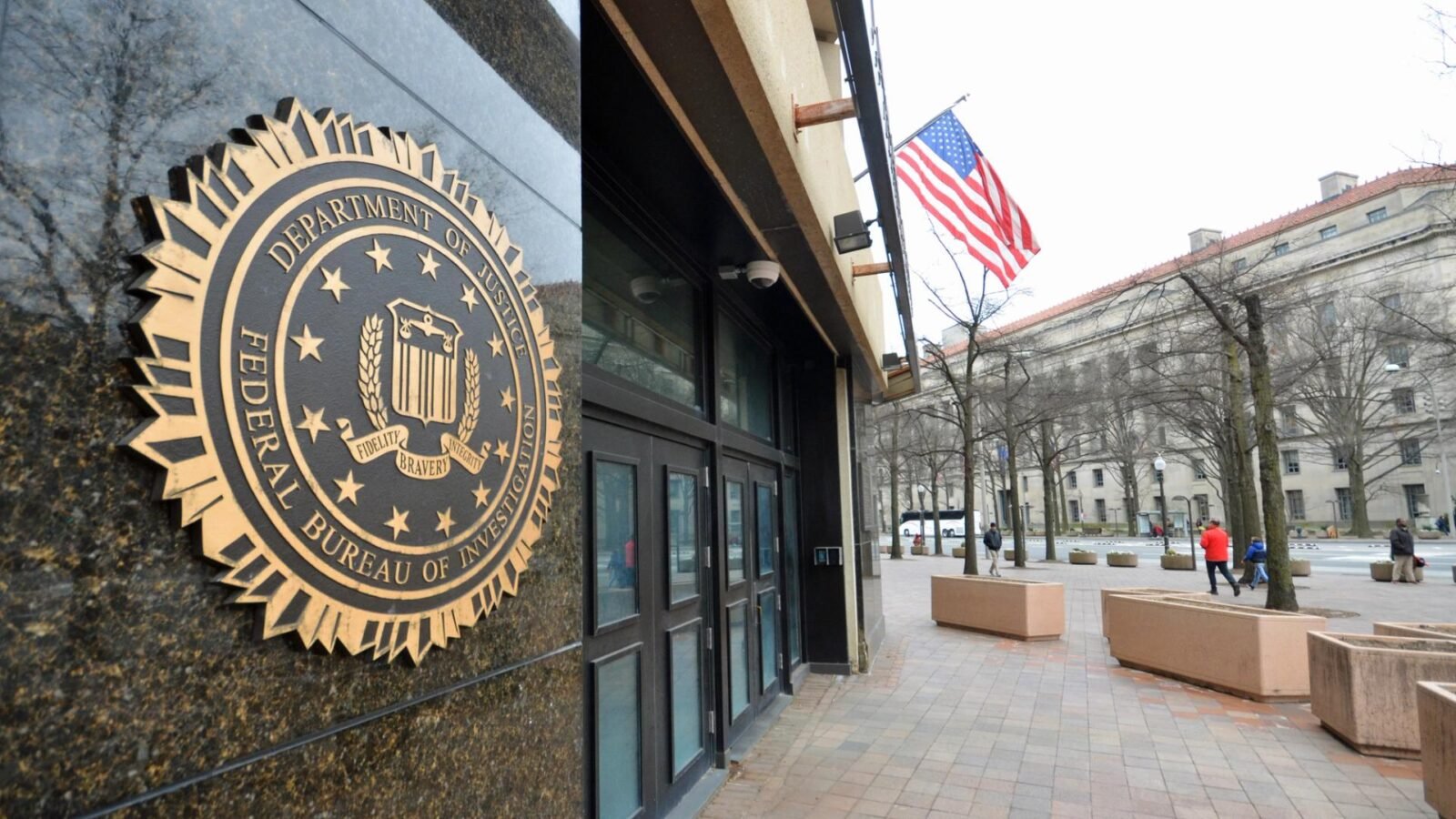 An FBI badge next to a cryptocurrency coin, symbolizing the alleged theft of digital assets by a federal agent.