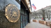 An FBI badge next to a cryptocurrency coin, symbolizing the alleged theft of digital assets by a federal agent.
