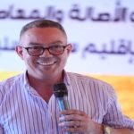 Fouzi Lekjaa s'adressant à la foule lors d'un rassemblement politique du PAM à Sidi Slimane, avec d'autres dirigeants du parti en arrière-plan.