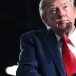 Un couple international, l'air préoccupé, devant une carte des États-Unis, symbolisant les défis de la GPA sous les politiques migratoires de Donald Trump.