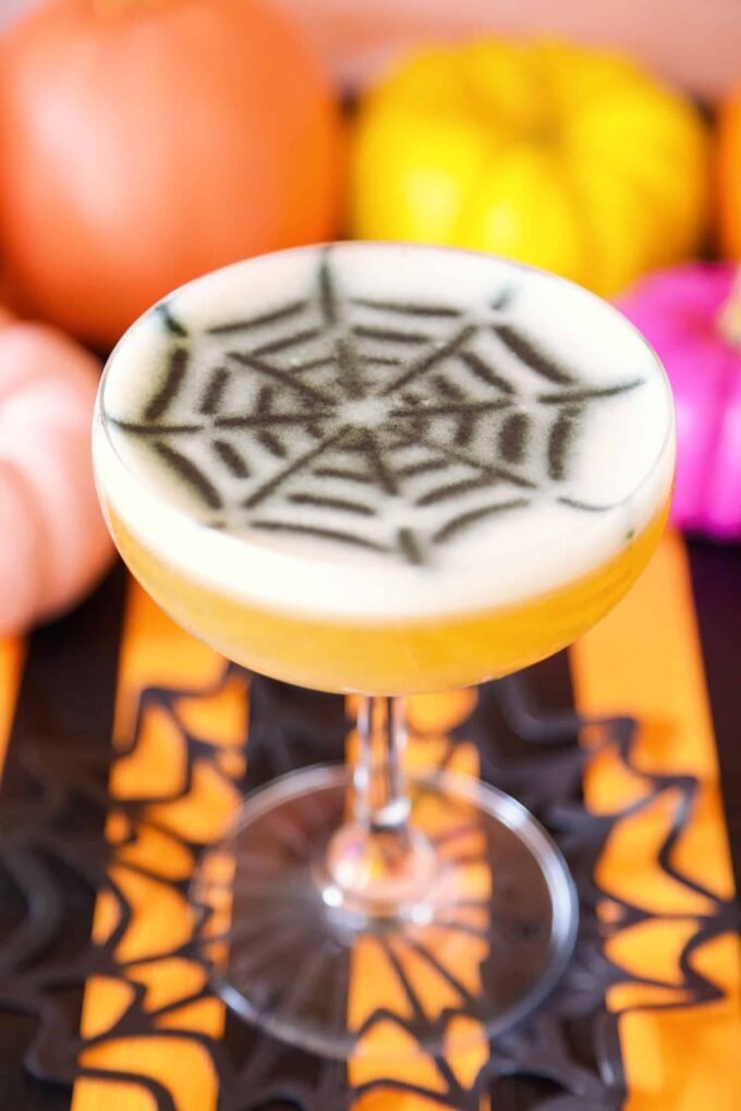 A collection of various Halloween-themed cocktails with spooky garnishes and decorations, set against a dark, festive background.
